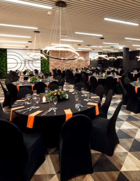 Spacious conference room with table arrangements and decorations, ready for a banquet