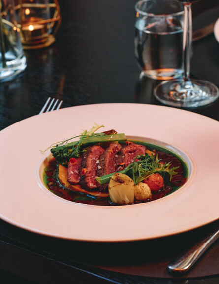 Wykwintne mięsne danie z sezonowymi warzywami i intensywnym sosem, serwowane w eleganckiej odsłonie