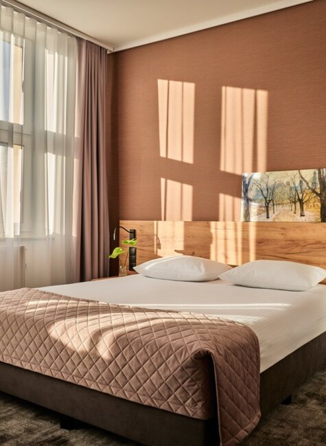 aranżacja łóżka dwuosobowego w pokoju hotelowym