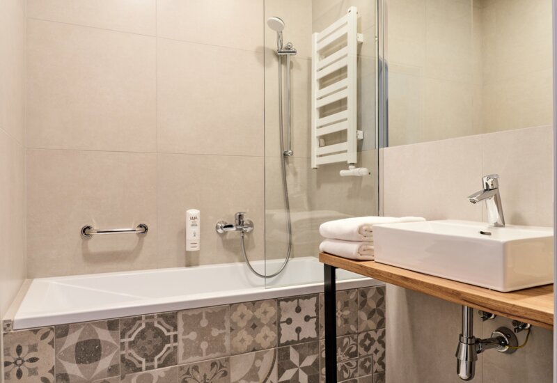 Bathroom at Garni Hotel with elegant finishes and a bathtub.