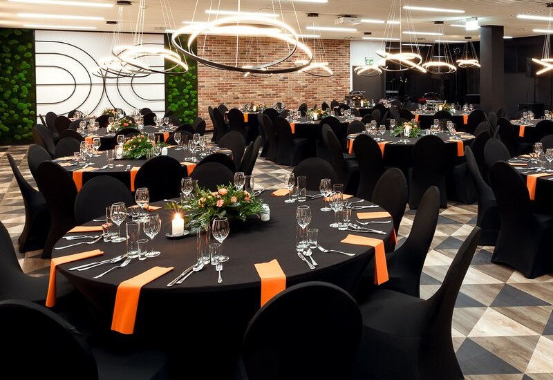 Spacious conference room with table arrangements and decorations, ready for a banquet