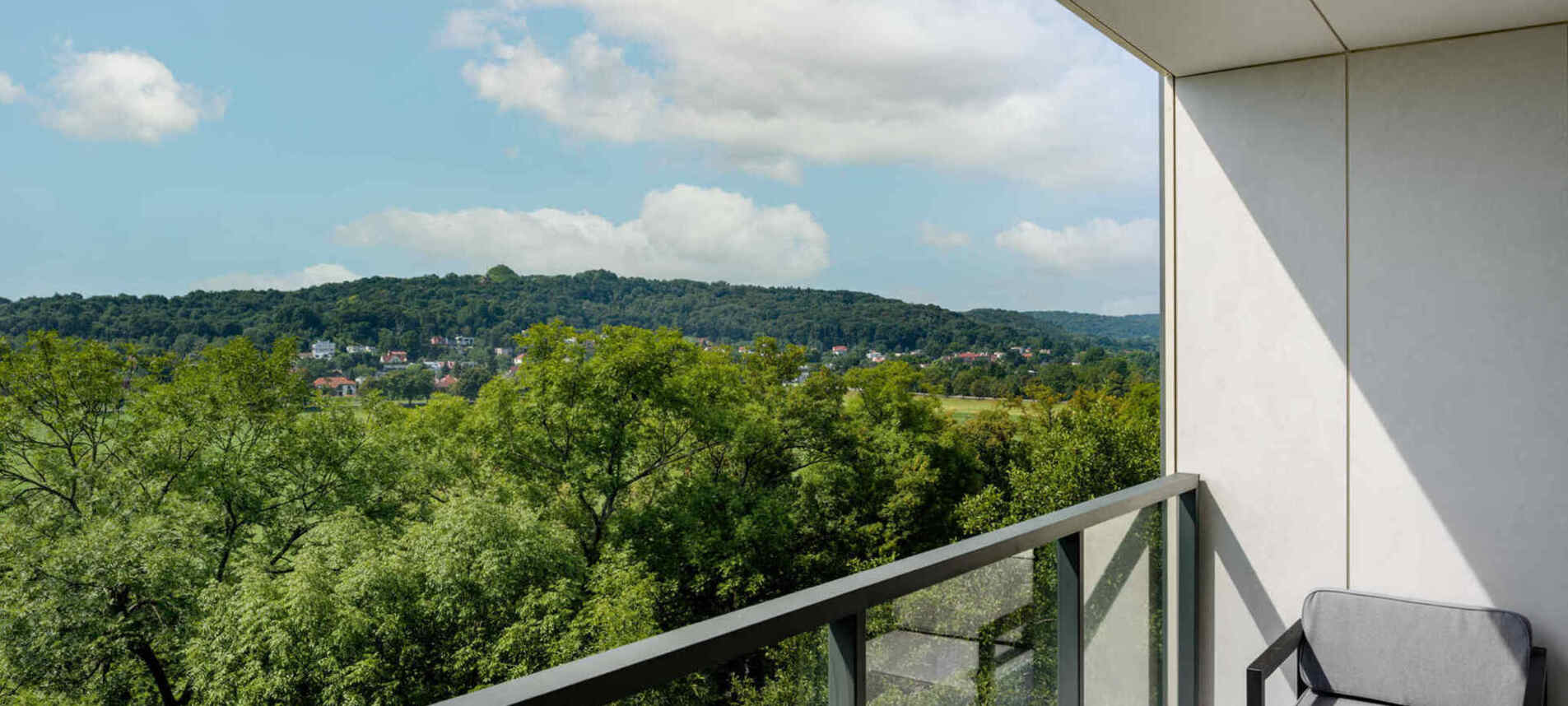 Widok zieleni otaczającej hotel z balkonu pokoju – spokojna i naturalna sceneria dla pełnego relaksu