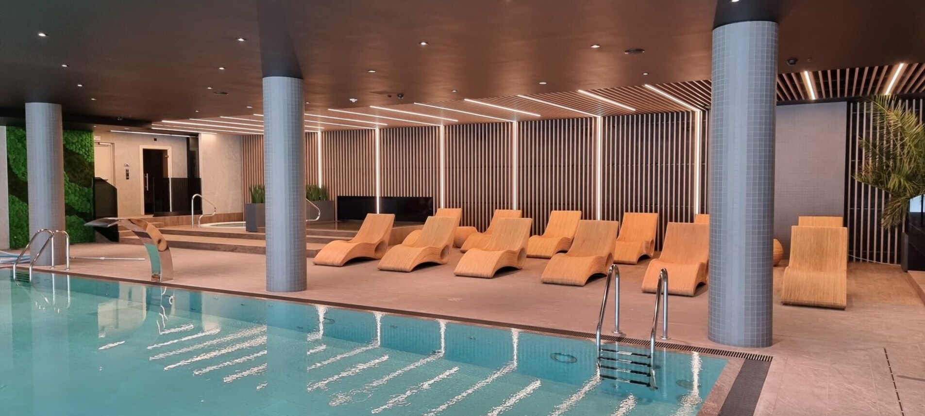 Wewnętrzny basen i komfortowe leżaki – idealne miejsce na relaks w luksusowym otoczeniu.