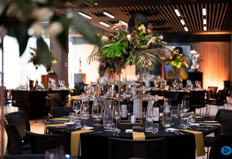 Elegant event hall arrangement – stylish table settings, subtle candles, and fresh flowers create a