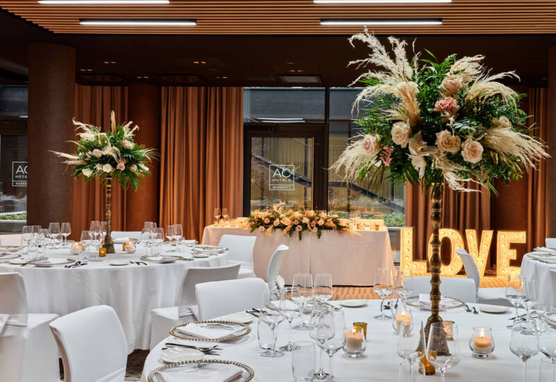 Event hall setup with elegant tables and chairs – the perfect space for a special occasion, combinin