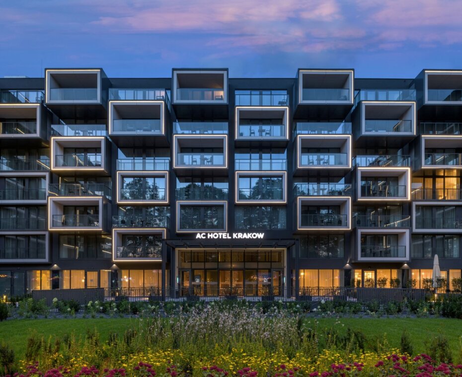 Elegancka fasada AC Hotel Kraków by Marriott widziana po zmroku, z subtelnym oświetleniem
