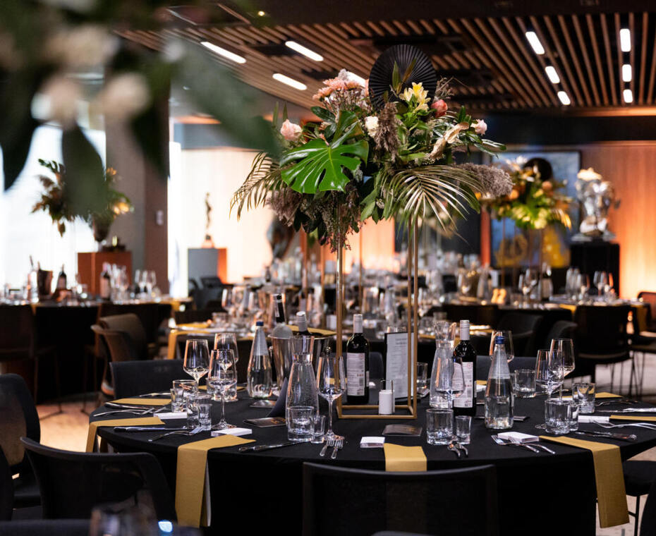 Elegant event hall arrangement – stylish table settings, subtle candles, and fresh flowers create a