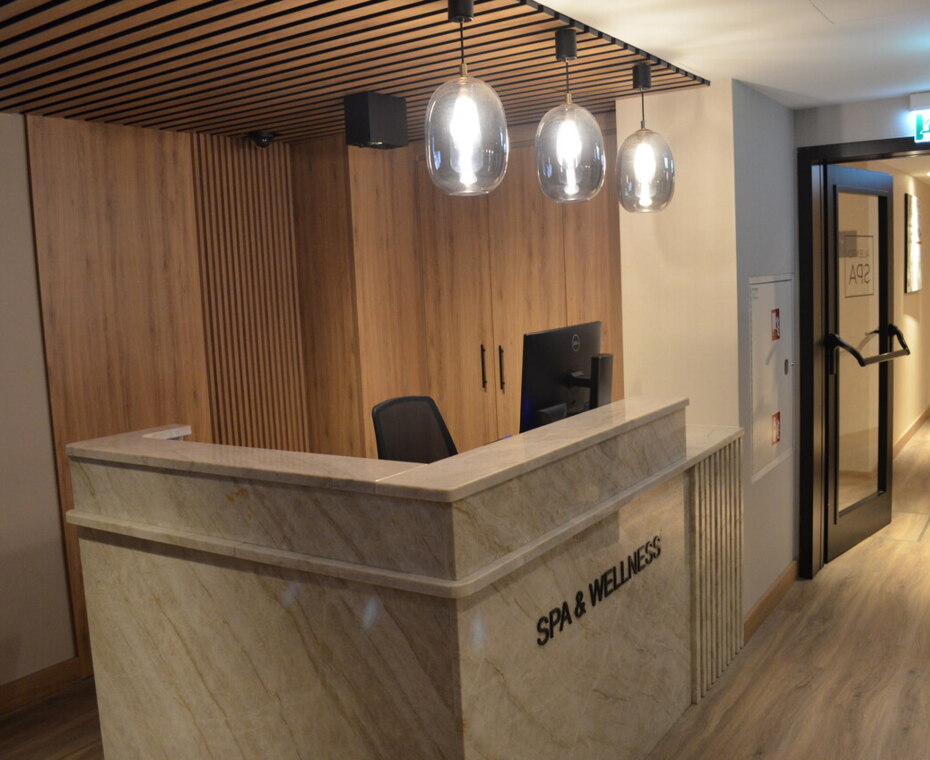 Recepcja strefy SPA & Wellness – eleganckie miejsce powitania gości spragnionych relaksu.