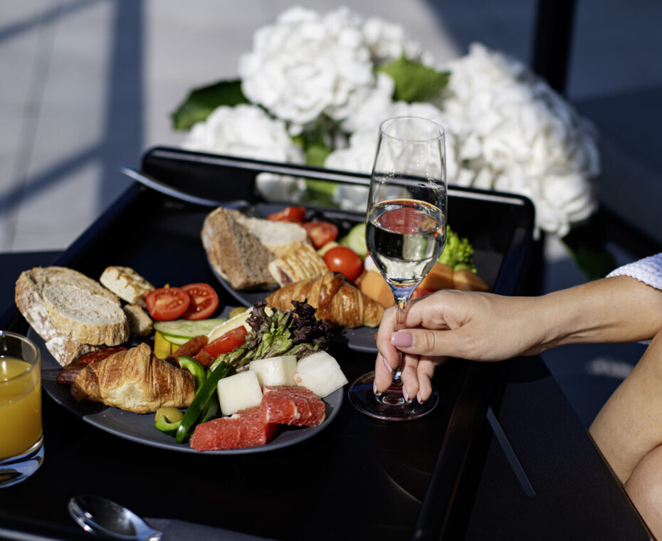 Model at the table, wine glass, and cheese platter in Sobre de la Mesa.