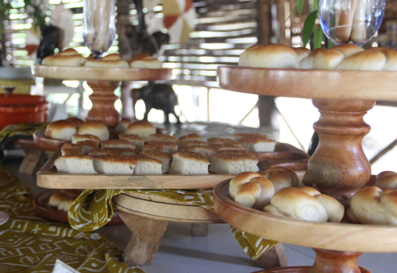 Freshly baked assorted breads displayed on tiered wooden trays, perfect for a hotel breakfast buffet setting