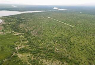 Secluded lakeside safari camp of canvas tents in green scrub, private dirt airstrip and winding river views over the savanna.