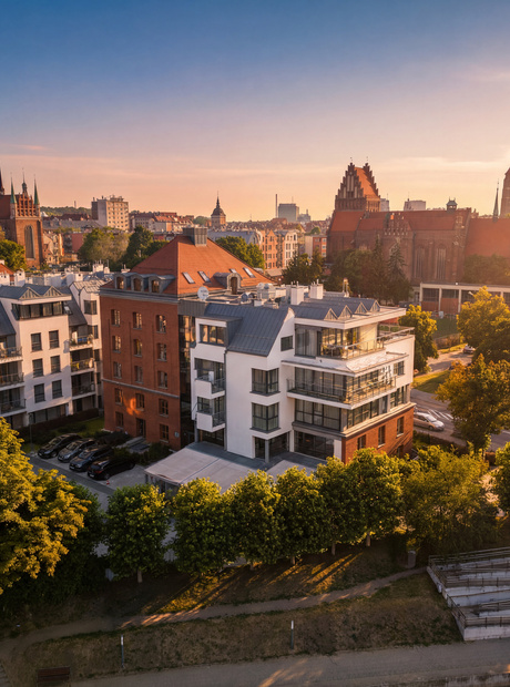 Moderne Hotelappartements mit Balkonen und Dachterrassen, sonnige Stadtansicht mit historischer Backsteinkathedrale