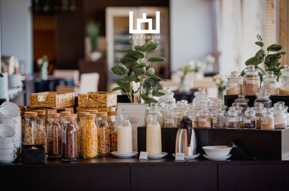 Elegancki bufet śniadaniowy w hotelu Platinum Ostróda z płatkami, mlekiem, jogurtami, kawą i dodatkami