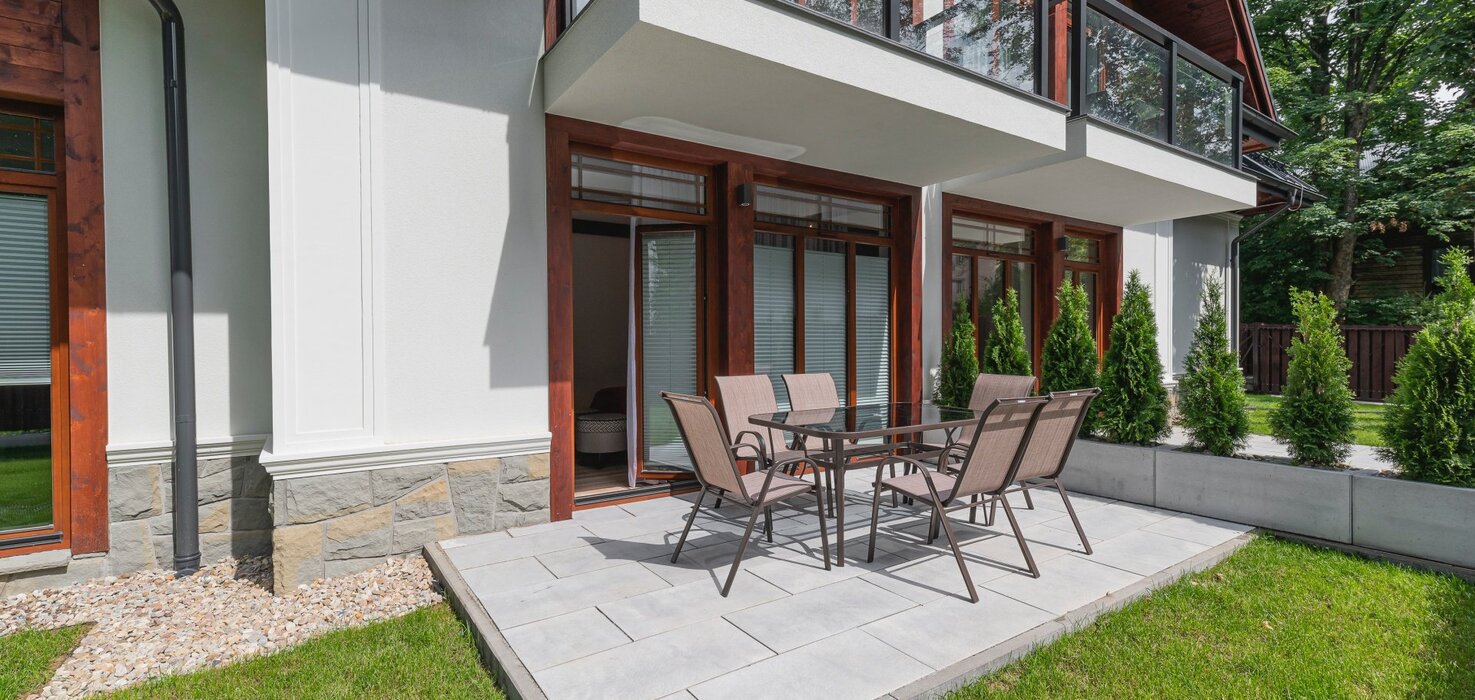 View of a small terrace with a table and six garden chairs.