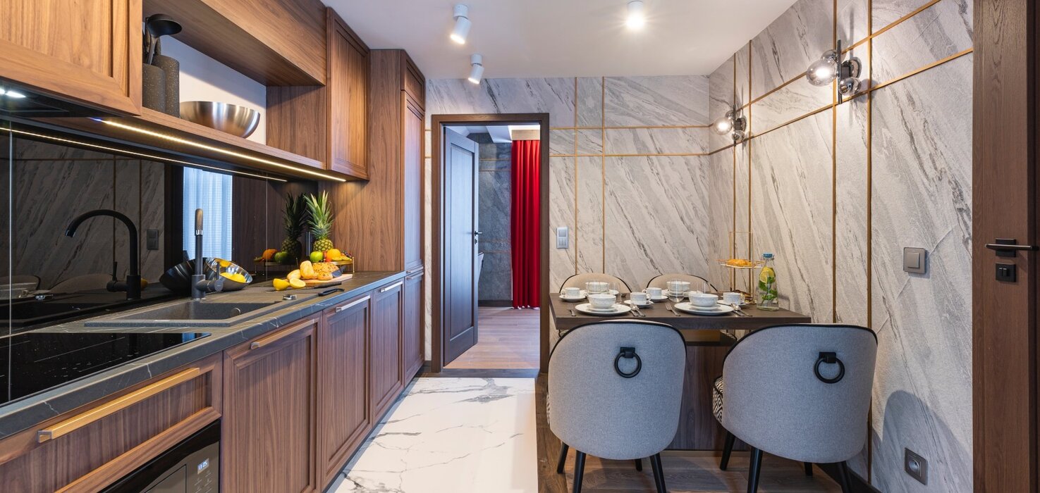 View of the hallway, with a kitchenette on the left and a dining table on the right.