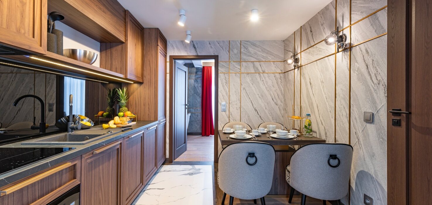 View of the hallway, with a kitchenette on the left and a dining table on the right.