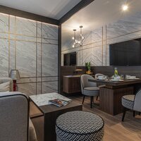 View of a set dining table for four, a coffee table, and a pouf.