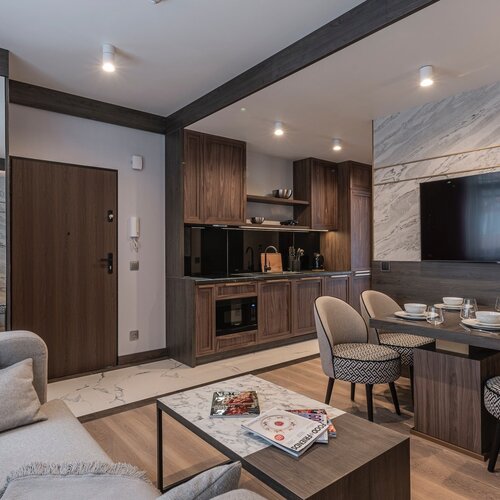 View of the living room with a sofa, coffee table and dining/kitchen area.