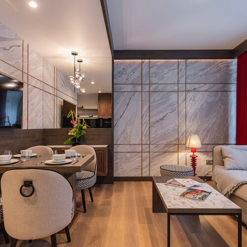 View of the living room with a sofa, coffee table and dining area.