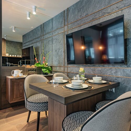 View of the dining table and television on the wall.