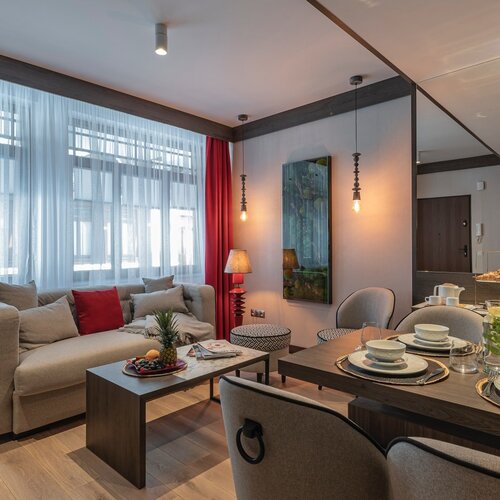 Living room with a sofa, coffee table, dining area and a painting on the wall.