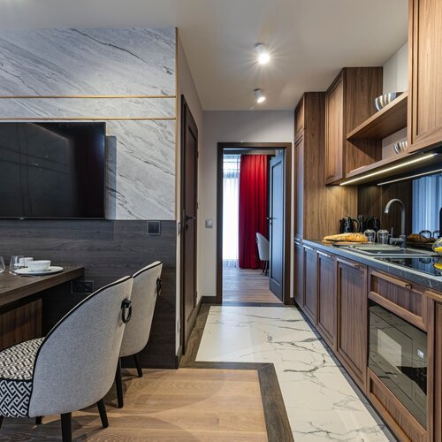 View of the hallway with kitchenette and part of the dining table with chairs.