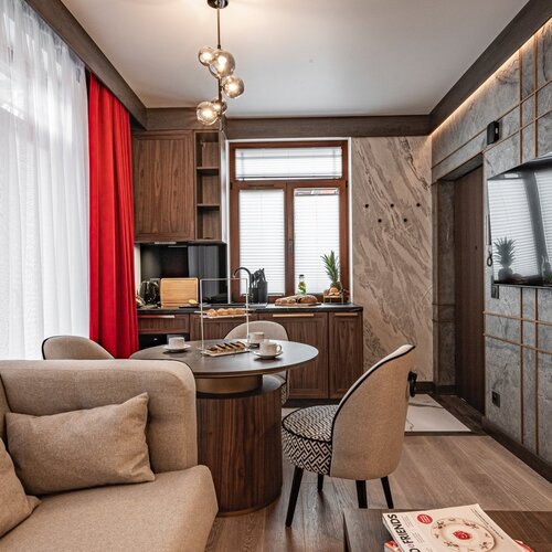 View of the dining and lounge area, with a sofa and a round table with chairs.