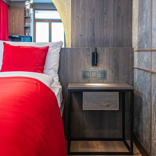 Bedside table with wall lamp next to the bed.