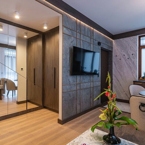 View of the apartment entrance, decorated with flowers and a television on the wall.