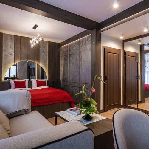 View of the living room with a sofa, coffee table and bed in an alcove.