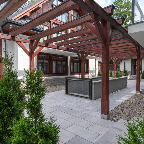 A wooden pergola between buildings.