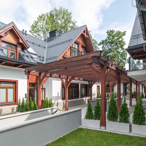 A wooden pergola between buildings.