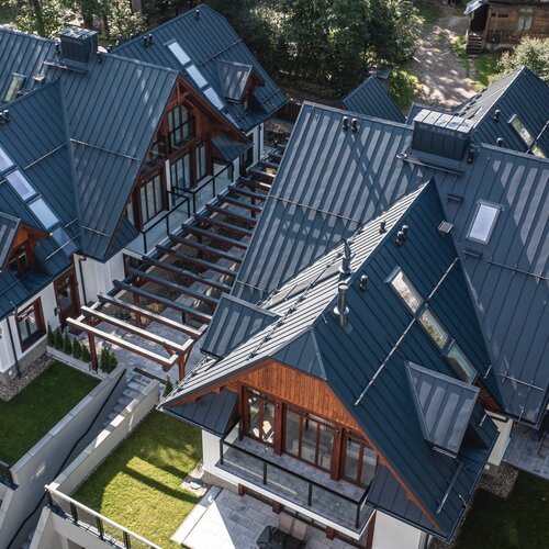 View from above of two modern two-storey houses in the Zakopane style.