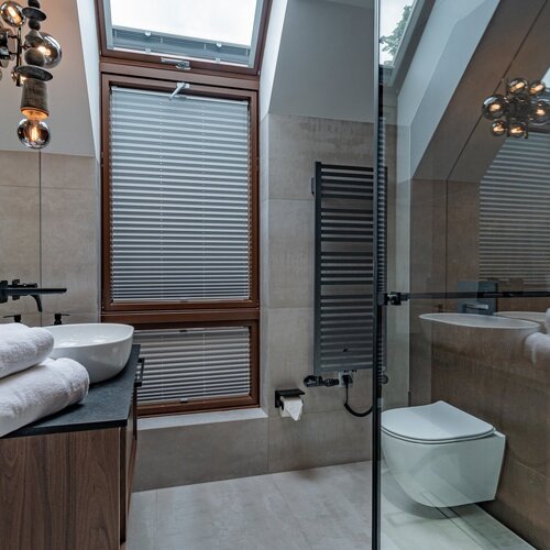 Bathroom with shower, washbasin and covered with a roller blind.
