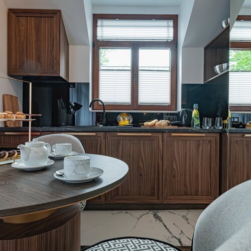 A table set with cups and saucers, placed next to the kitchen.