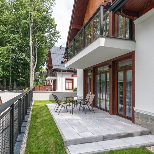 Terrace with lawn, table and chairs at the entrance to the flat.