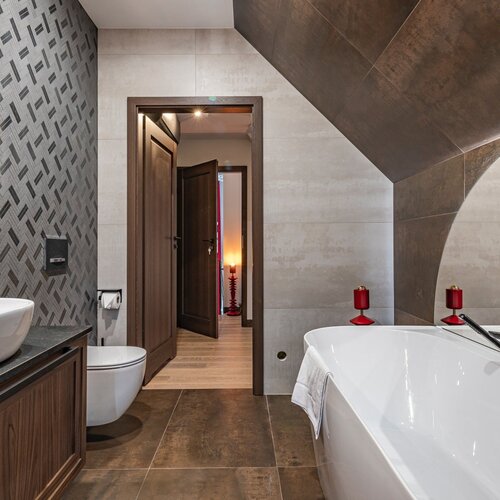 View of the bathroom with a large bathtub and dark cabinet.