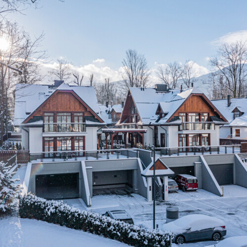 A view of modern houses in the Zakopane style covered with snow.