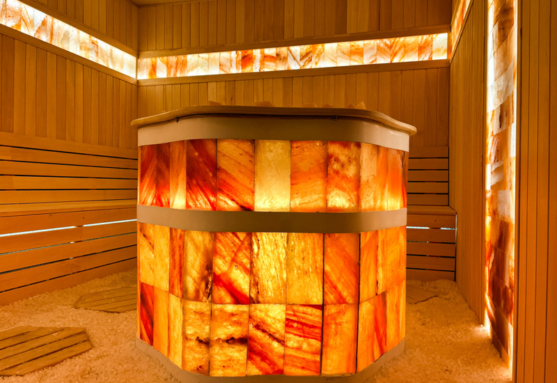 Przytulna sauna z podświetlanymi panelami solnymi i drewnianymi ławkami, stworzoną dla relaksu gości.