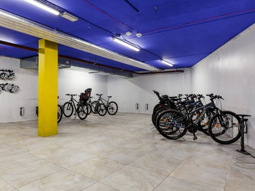 Przestronna, podziemna wypożyczalnia rowerów z nowoczesnymi kaskami i bezpiecznym miejscem na przechowanie.