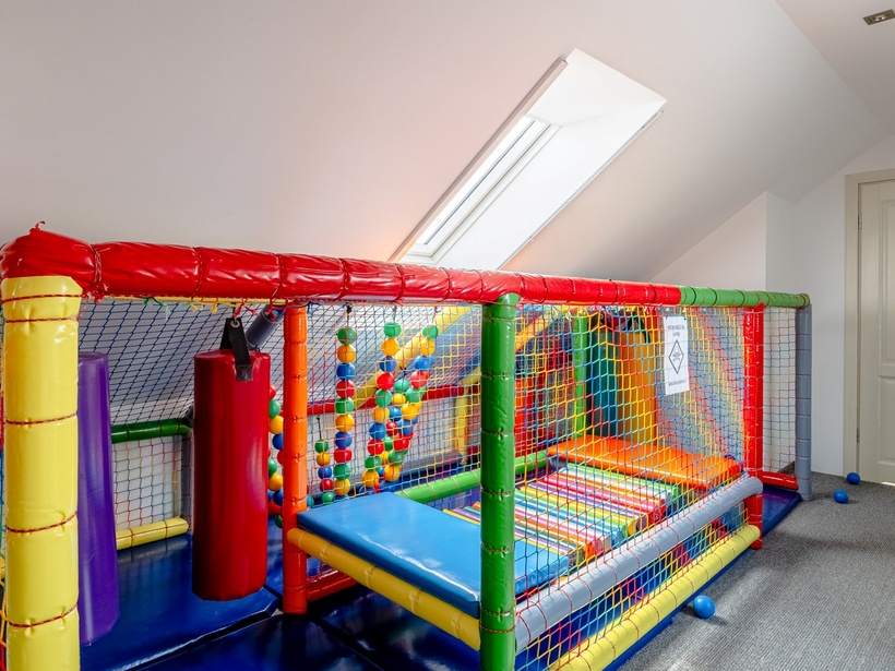Kolorowy wewnętrzny plac zabaw na poddaszu z miękkimi przeszkodami, piłeczkami i strefą zabaw dla dzieci
