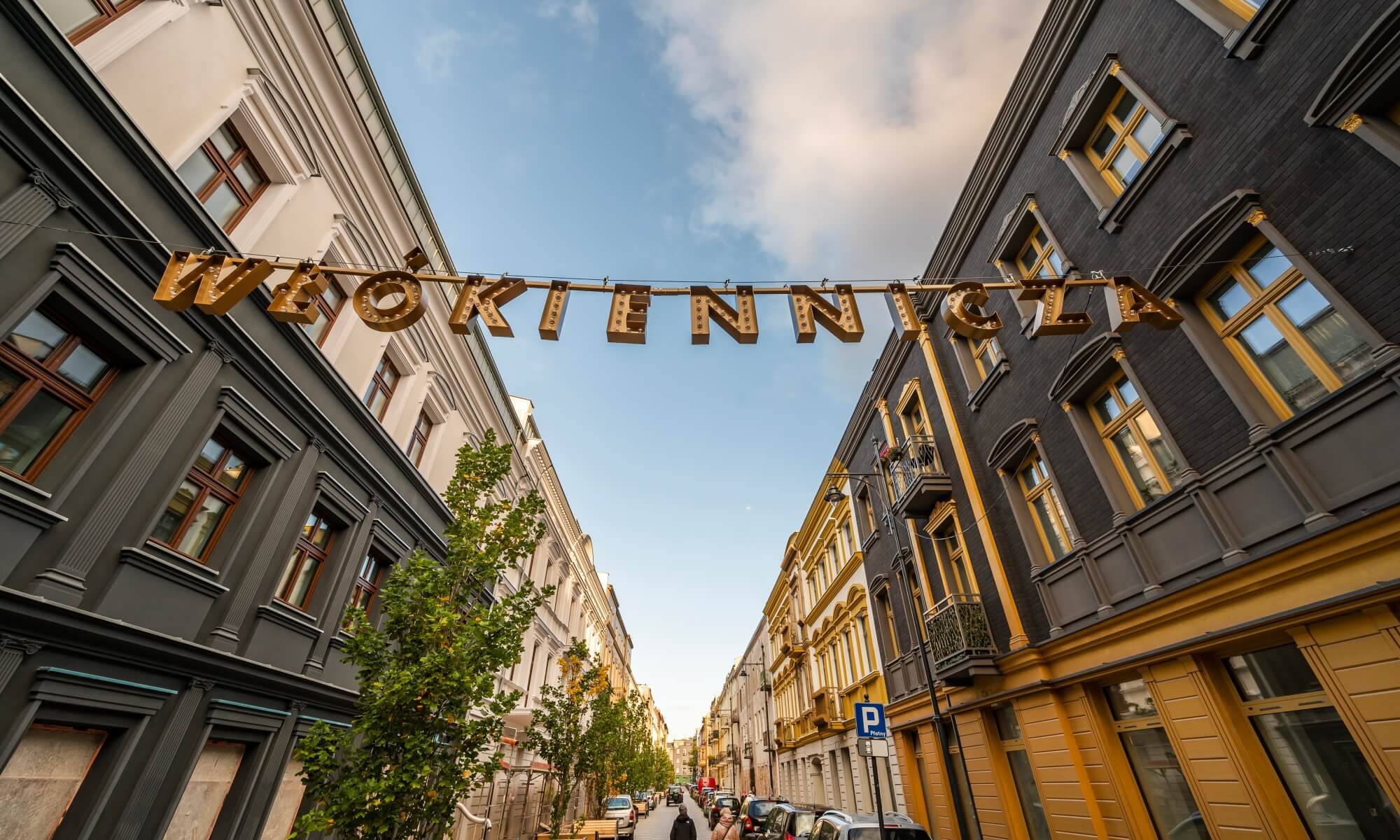 Ulica Włókiennicza w Łodzi – odnowione kamienice i charakterystyczny napis nad ulicą