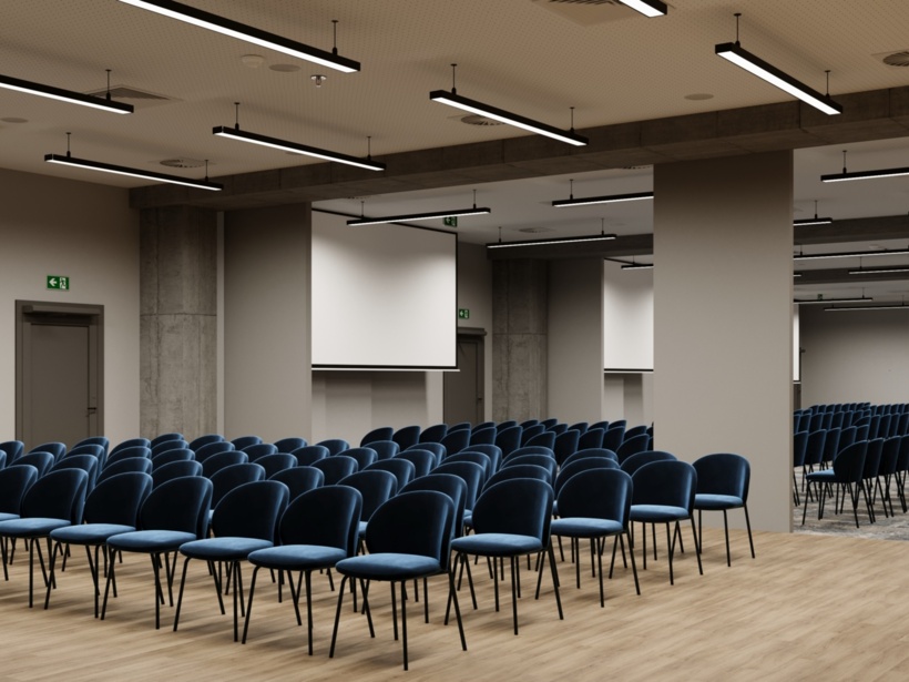 Sala konferencyjna z ustawionymi krzesłami i ekranem do prezentacji