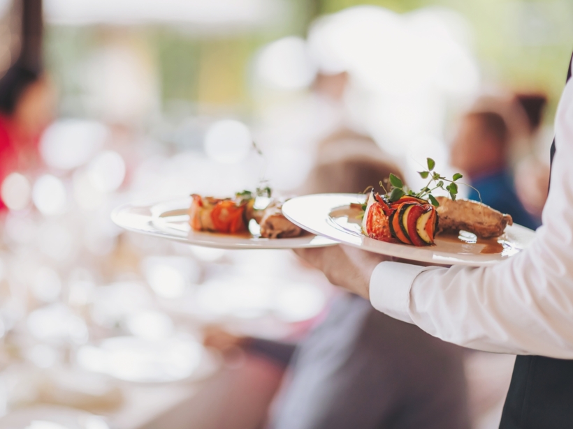 Kelner niosący potrawy obiadowe przyrządzone w restauracji dla gości