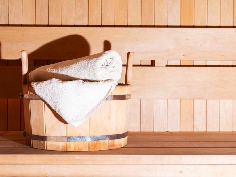 Drewniana sauna hotelowa z ręcznikiem i wiaderkiem na wodę