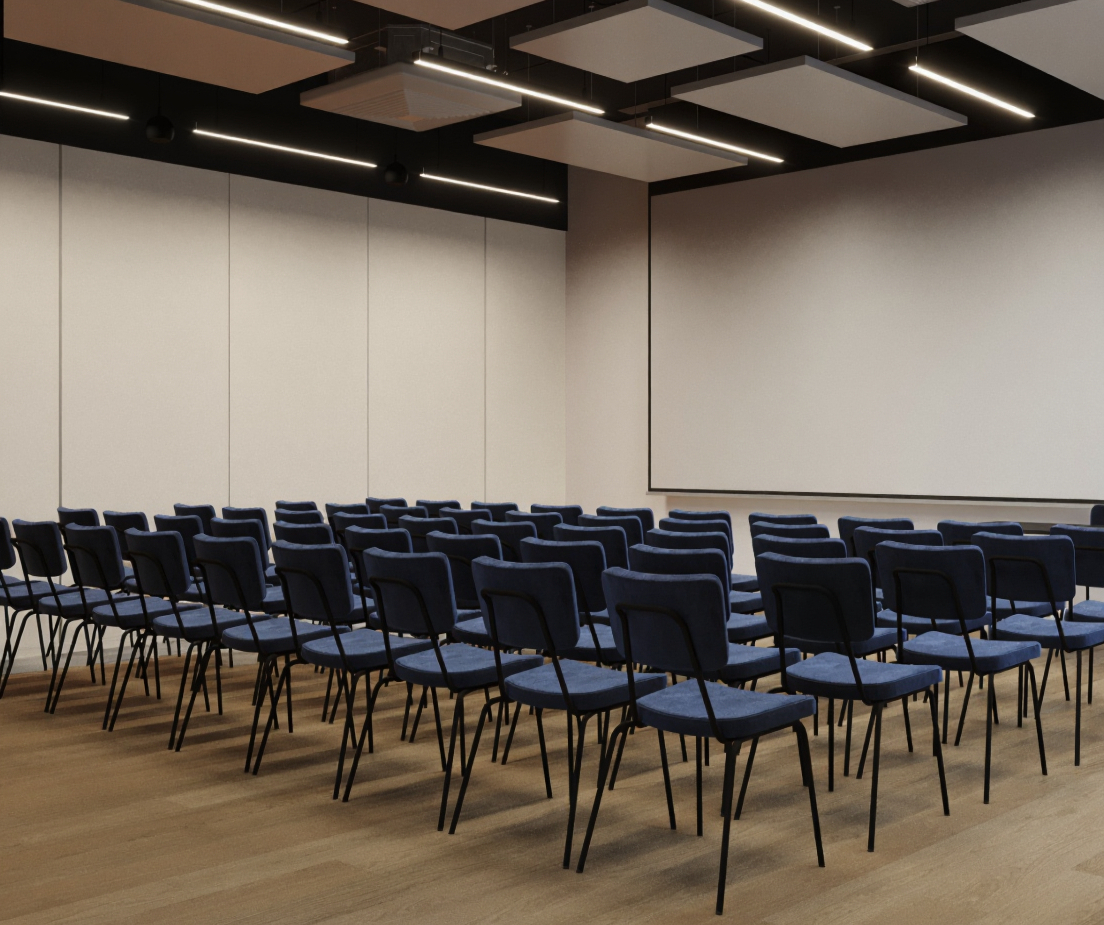 Sala konferencyjna z rzędami niebieskich krzeseł, dużym ekranem projekcyjnym, drewnianą podłogą i nowoczesnym oświetleniem.