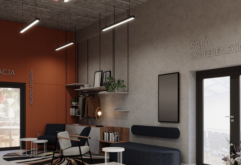 Lobby w stylu industrialnym z wygodnym siedziskiem, stolikami, wieszakami i wejściem do sali konferencyjnej.