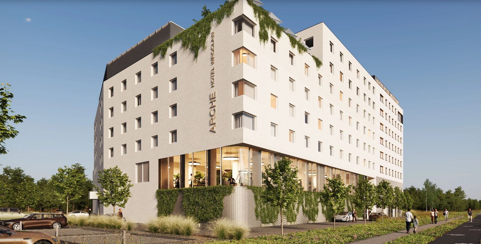 Nowoczesny hotel z zielonymi elewacjami i dużymi oknami restauracji na parterze, otoczony drzewami i parkingiem