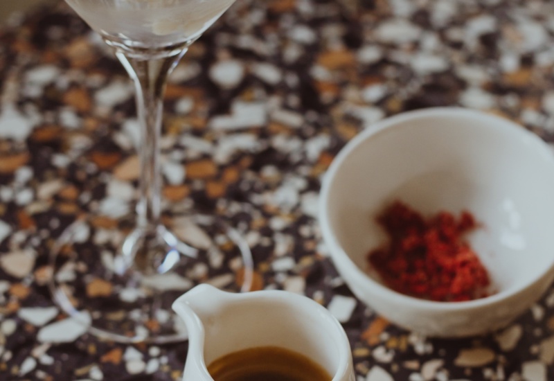 Small coffee jug and white bowl with spices on a colorful mosaic patterned table surface