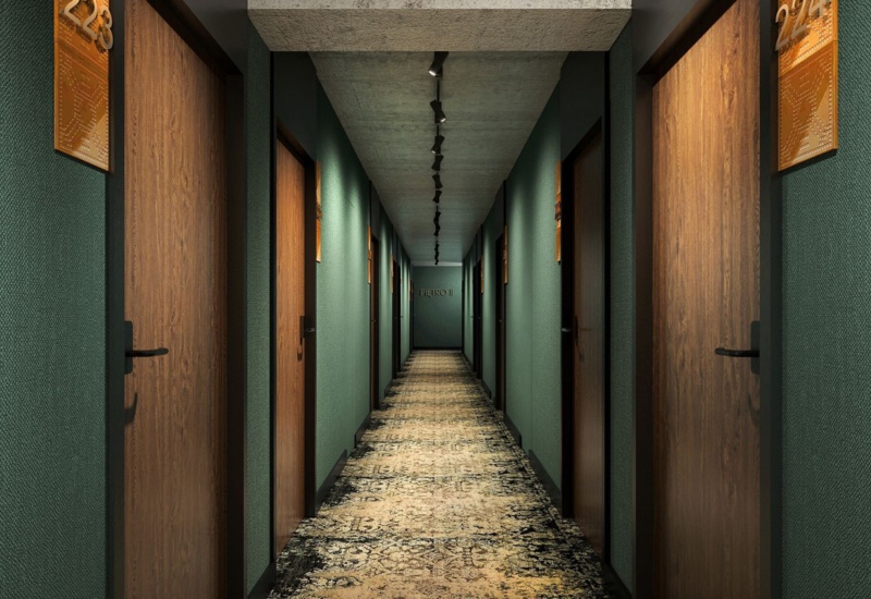 Hotel corridor with dark green walls, wooden doors, and patterned carpet leading to the Piero II room.
